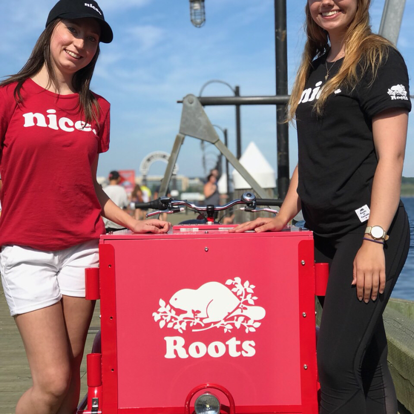 Two roots canada representitves pose with an Icicle Tricycles branded Ice Cream outdoor advertising Bike in Toronto