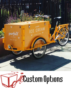 Icicle Tricycle Parfait branded custom Ice cream bike in parked on the side walk and the Icicle Tricycle logo with text "Vending Bikes" adjacent