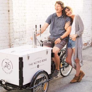 a couple posing with the nitro bike cold brew coffee bike in an alley way